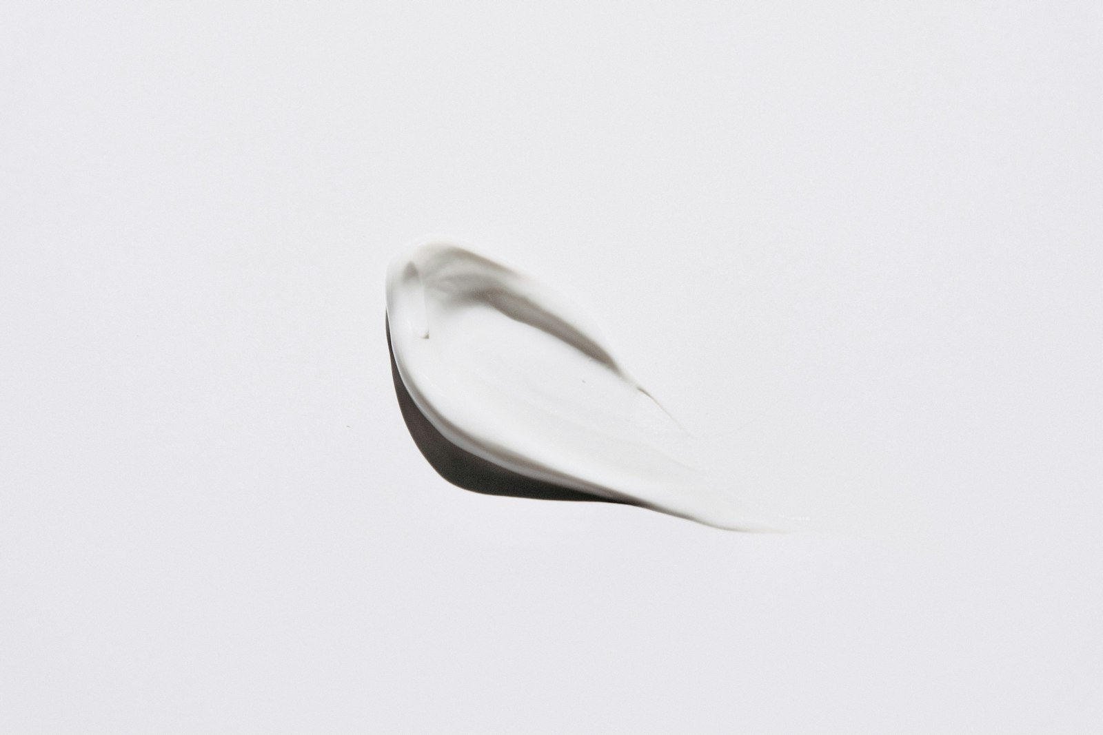 A swipe of white moisturizing cream on a pale background